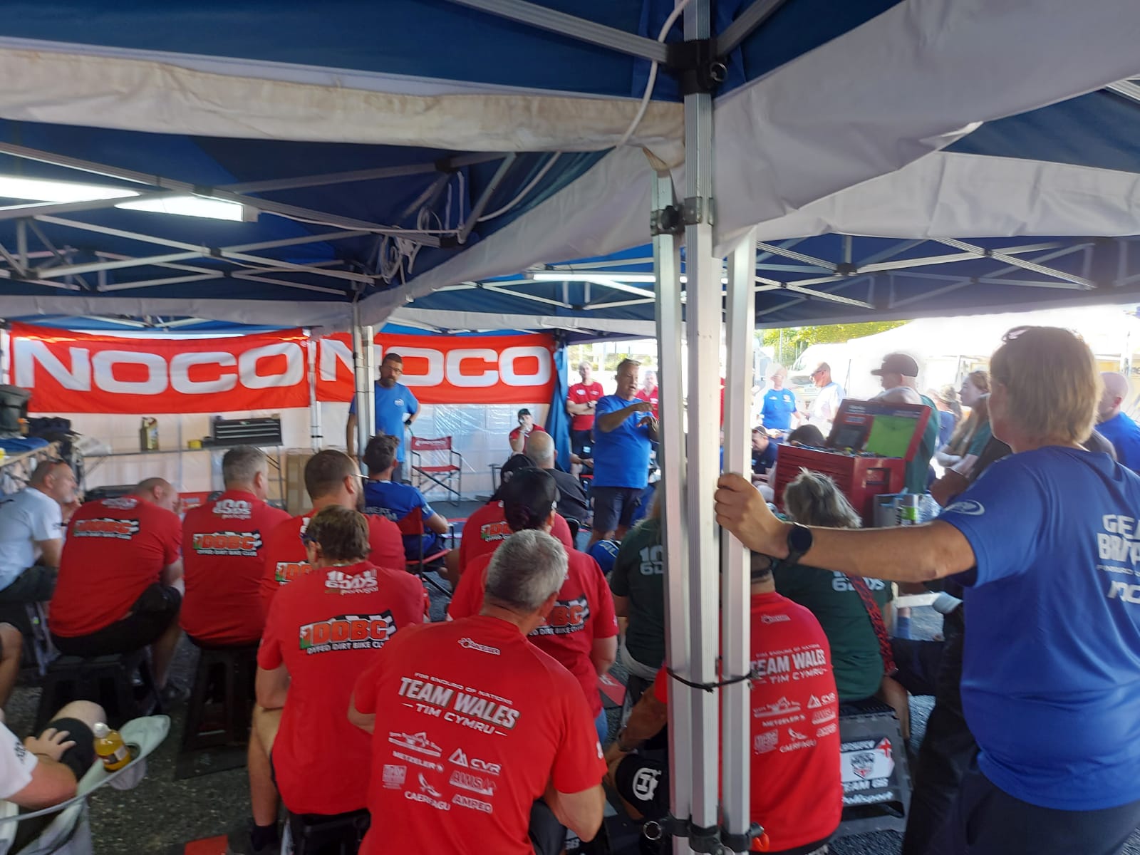 Scottish enduro riders and support crews during a team briefing at the FIM 6DAYS Portugal paddock